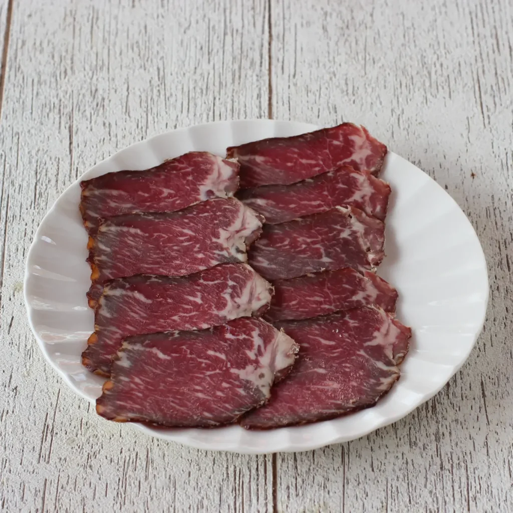 Beyaz tabakta dilimlenmiş Boşnak kontrafile kuru et